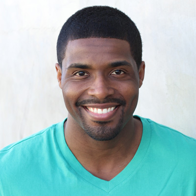 The image shows two elderly individuals, an older man and woman, smiling at each other and embracing while posing for a photograph.